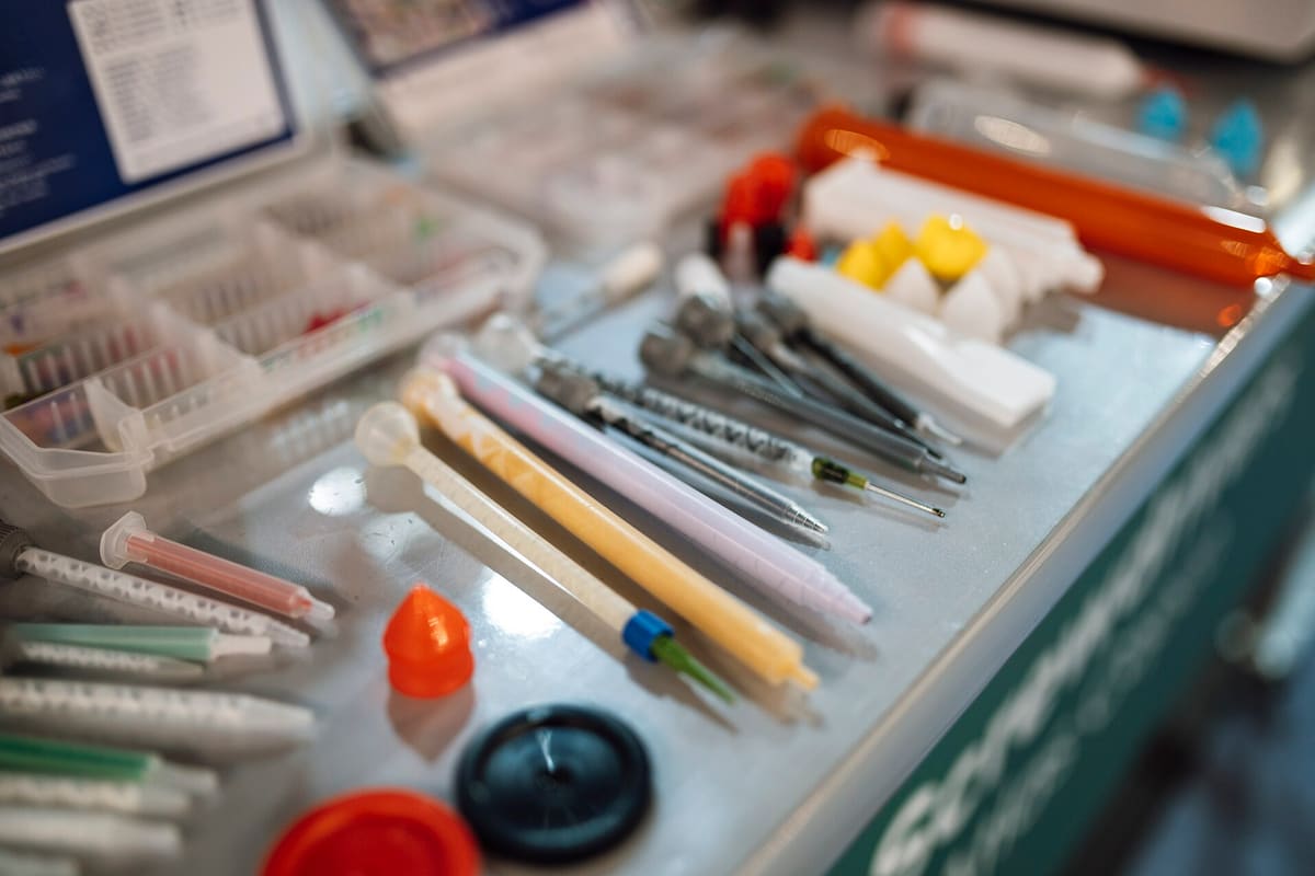 Tablett mit sortiertem Laborzubehör: Spatel, Pipettenspitzen und Verschlusskappen
