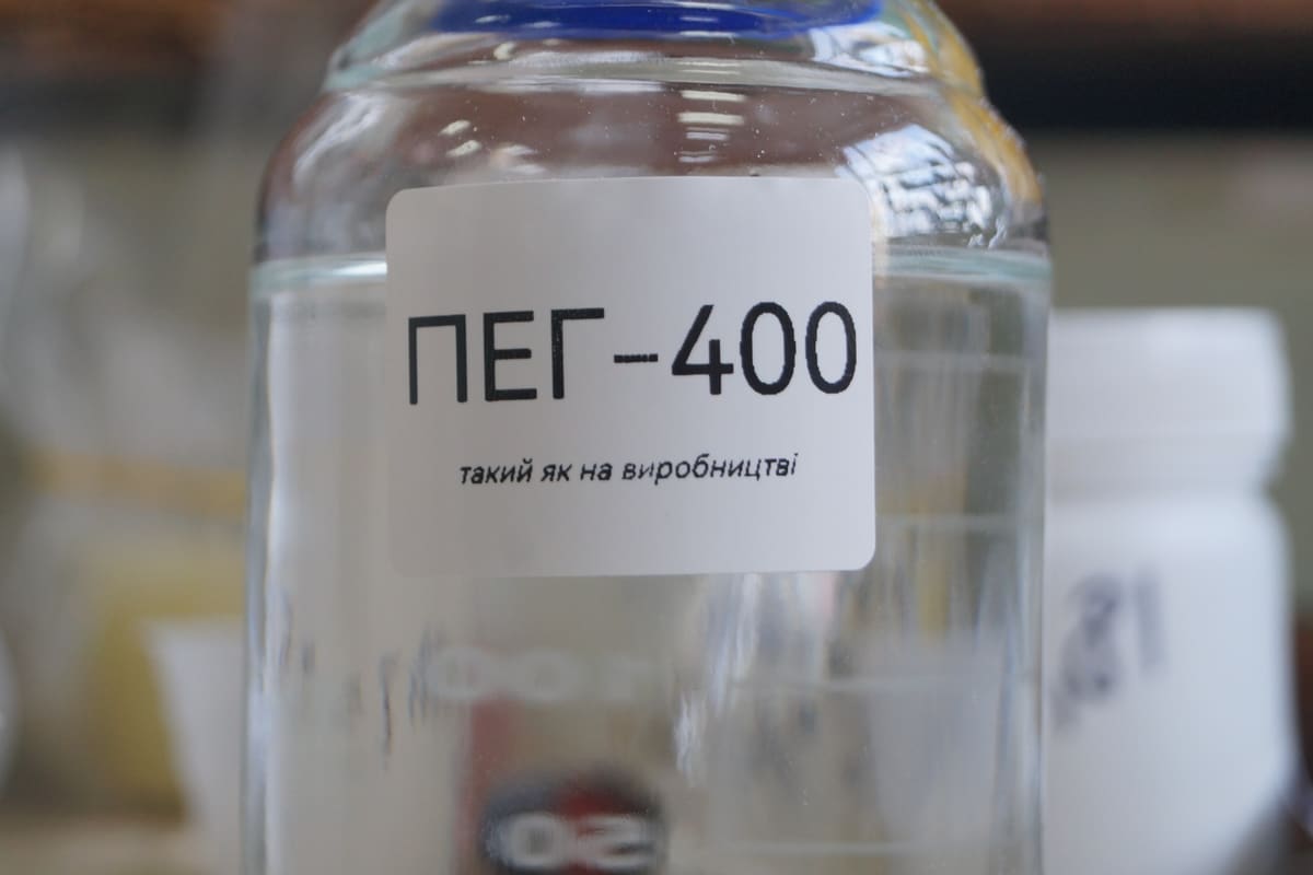 Vorratsflasche mit gedrucktem Substanzetikett vor unscharfem Laborhintergrund