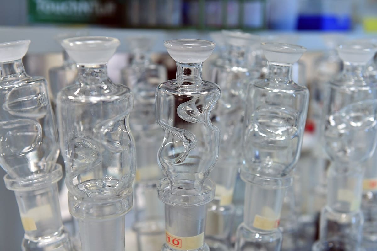 Dicht gestellte Reihe leerer Laborgläser mit engem Hals, Nahaufnahme