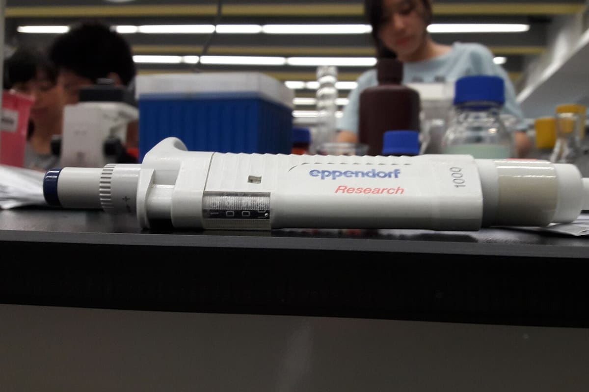 Kolbenhubpipetten auf einer Laborbank, im Hintergrund unscharf ein Arbeitsplatz