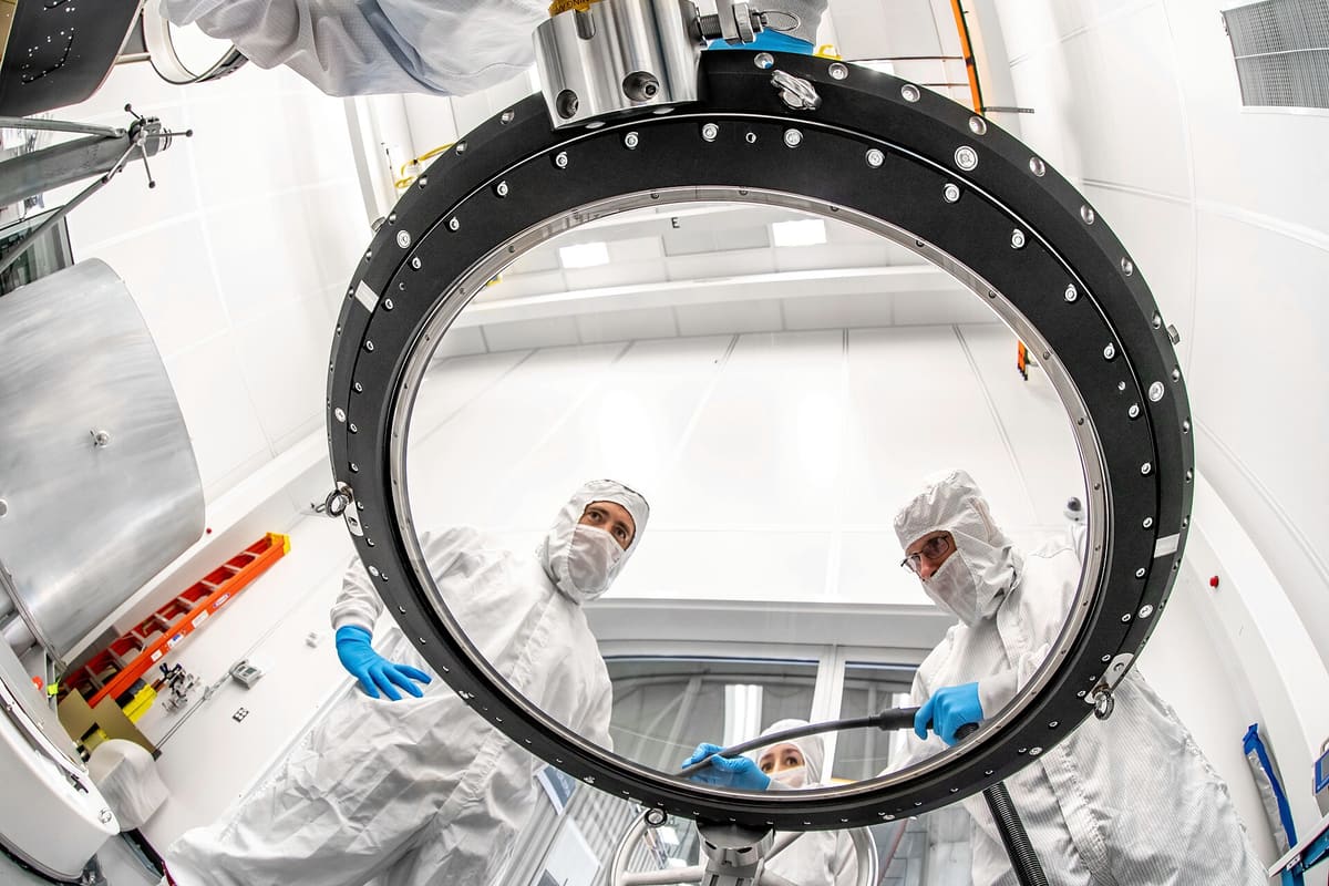 Blick durch einen Metallring auf Reinraumpersonal bei der Montage