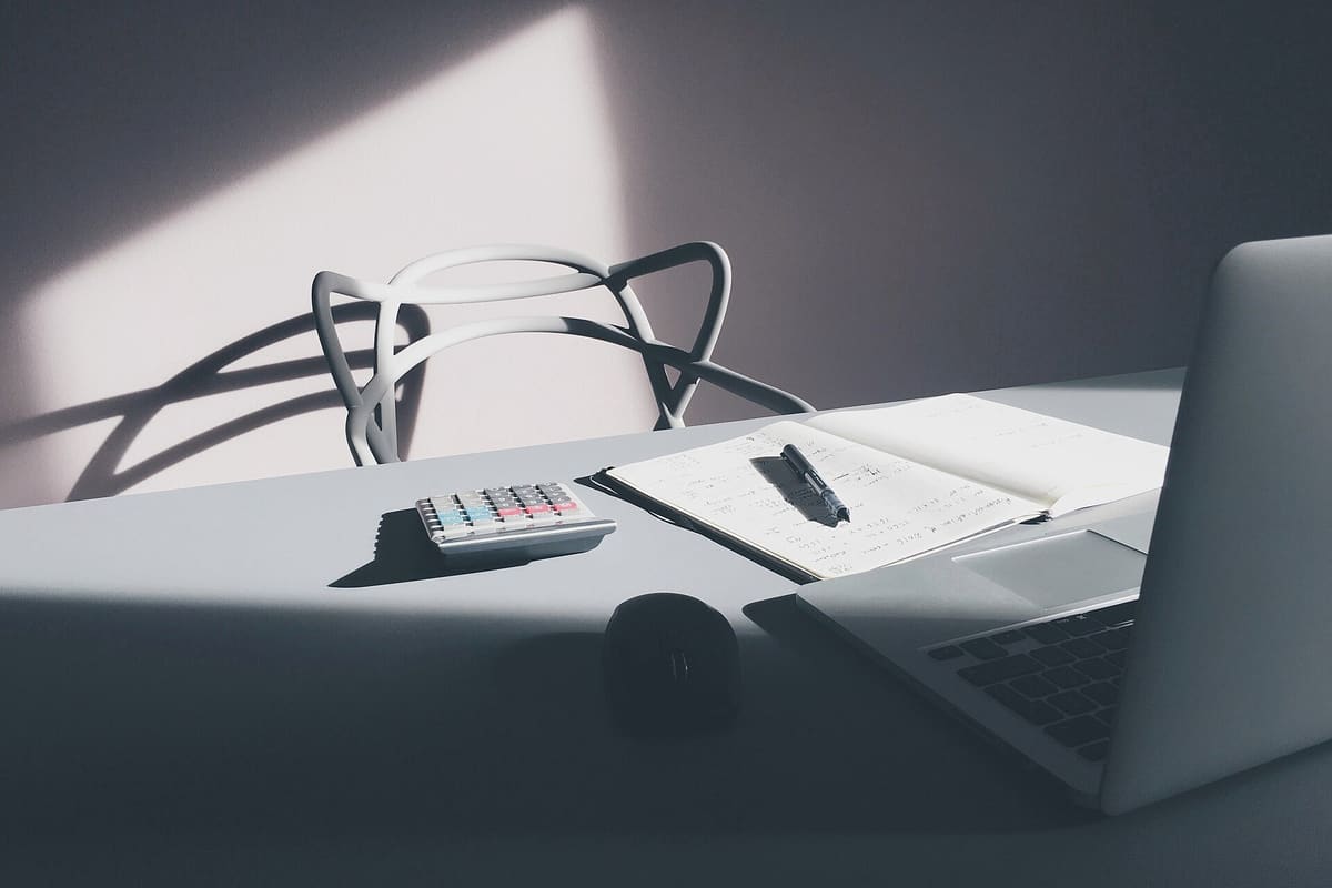 Schreibtisch mit Laptop und Taschenrechner