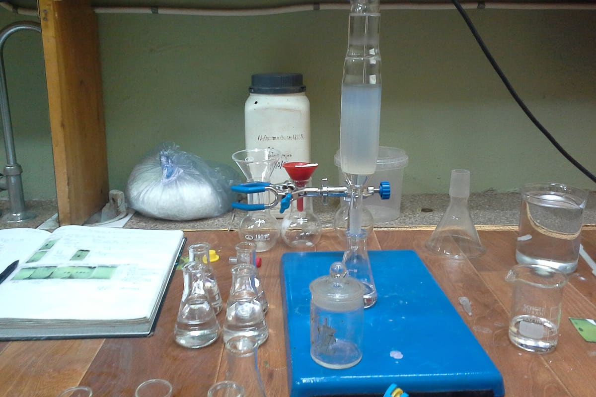 Laborbank mit Filtrationsaufbau, Erlenmeyerkolben und Reagenzflaschen