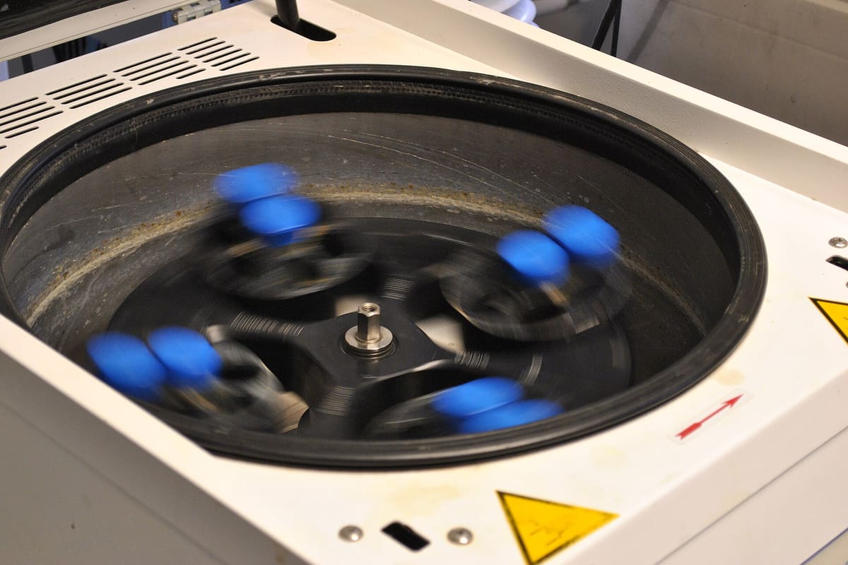 Zentrifugenrotor mit eingesetzten Probenröhrchen unter geöffnetem Deckel