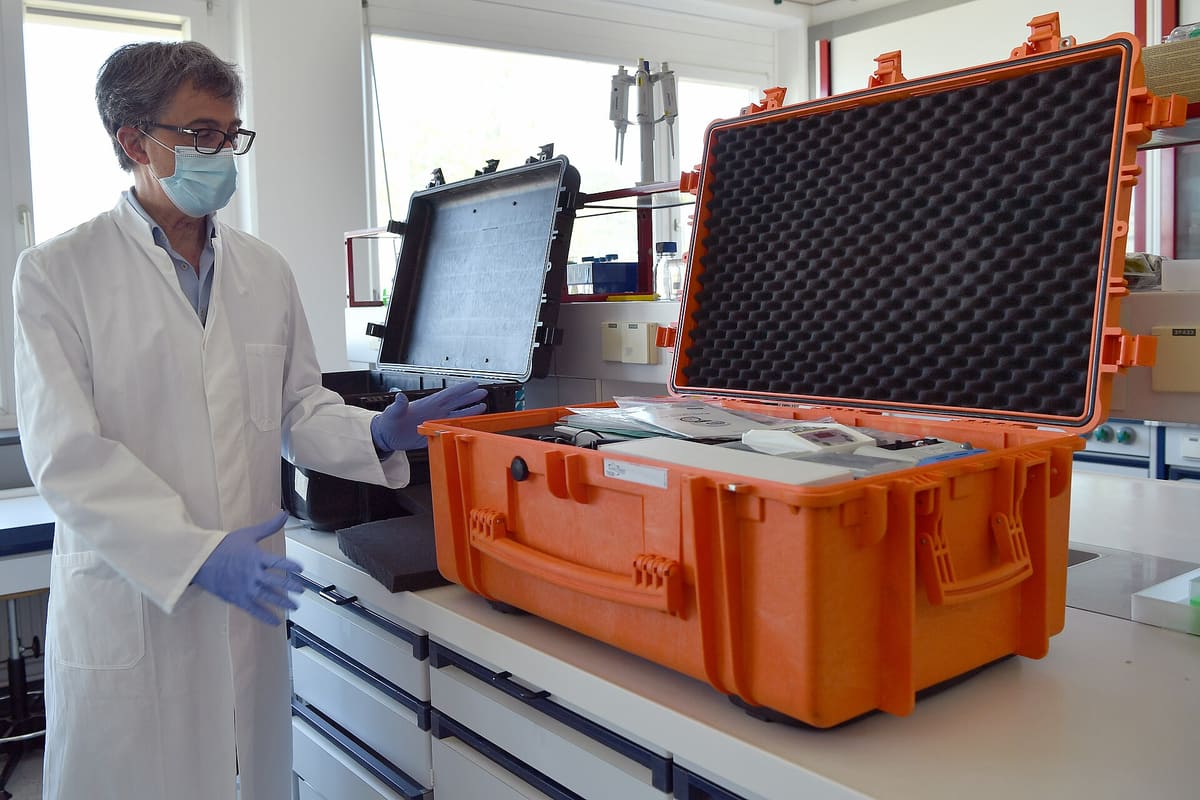 Wissenschaftler öffnet einen Transportkoffer mit Messtechnik im Labor